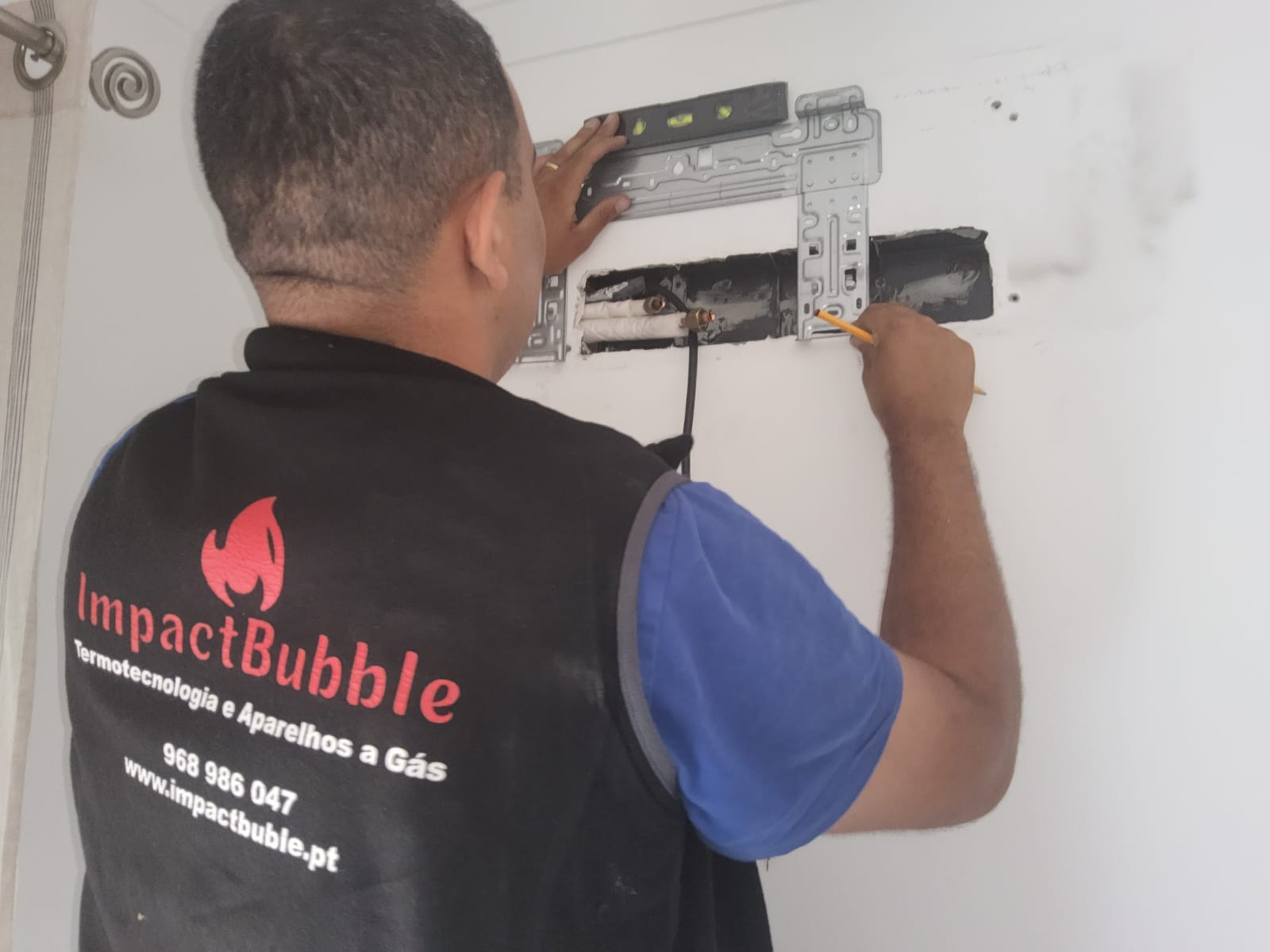 Técnico ImpactBubble a marcar suporte para instalação de ar condicionado interior