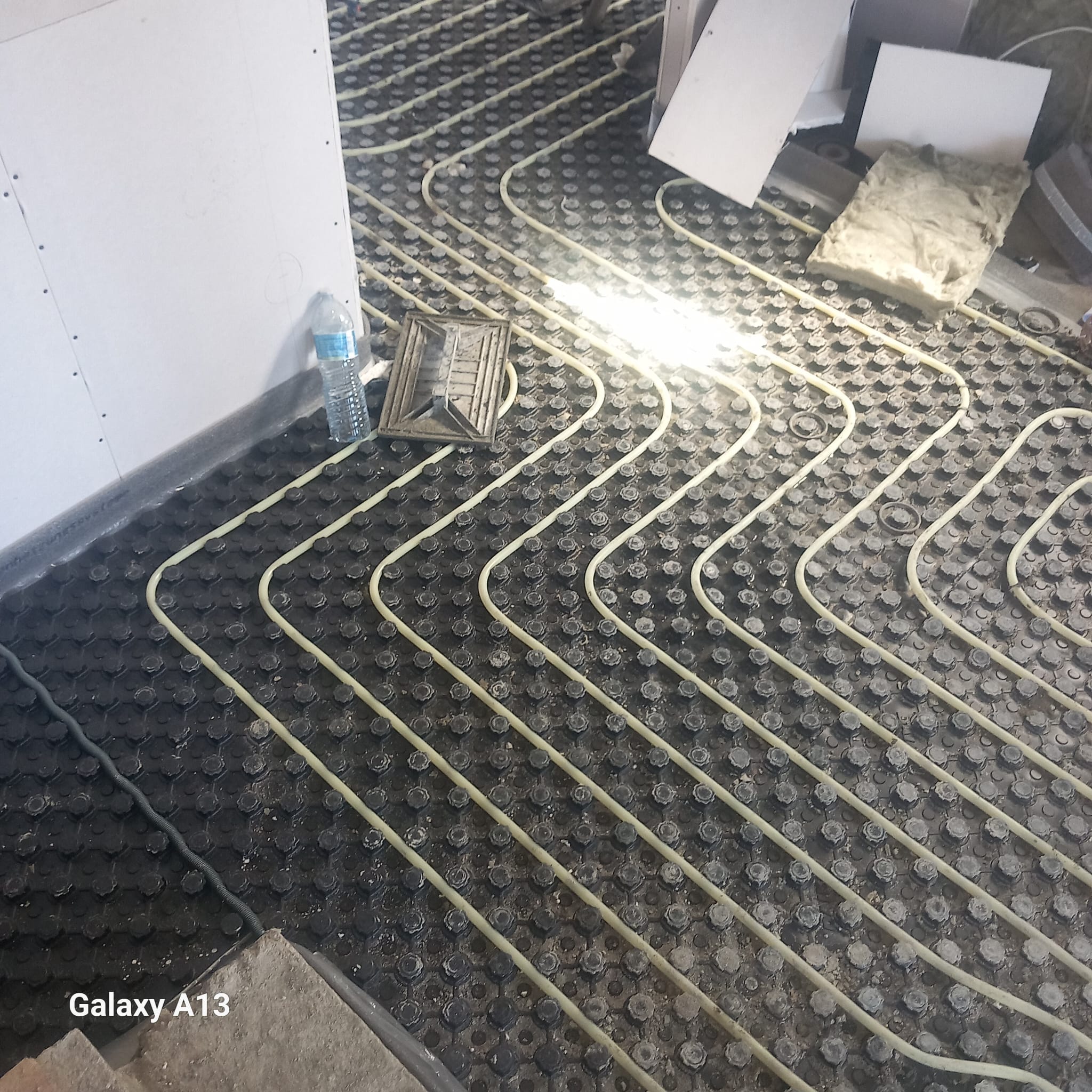 Tubagem de piso radiante organizada antes do acabamento do pavimento